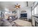 Open concept living room shows wood floors, tv set up, and ceiling fan at 12069 Monaco Ct, Brighton, CO 80602
