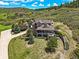 Aerial view of an elegant stone home nestled amongst trees, showcasing the surrounding landscape at 4222 Serenade Rd, Castle Rock, CO 80104