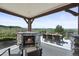 Covered deck featuring a stone fireplace and outdoor dining area, perfect for entertaining with a scenic backdrop at 4222 Serenade Rd, Castle Rock, CO 80104