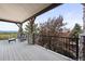 Covered deck with wood floors and stone pillars, offering a comfortable seating area with scenic views at 4222 Serenade Rd, Castle Rock, CO 80104