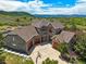 Aerial view of a stone house featuring a three-car garage and a basketball hoop in the driveway at 4222 Serenade Rd, Castle Rock, CO 80104