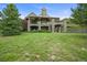 Stunning stone home with multiple covered patios, lush landscaping, and a sprawling lawn at 4222 Serenade Rd, Castle Rock, CO 80104