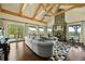 Open living room featuring a vaulted ceiling with exposed beams, a stone fireplace, and scenic outdoor views at 4222 Serenade Rd, Castle Rock, CO 80104