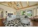 Spacious living room featuring a vaulted ceiling with exposed beams, large windows, and comfortable sectional seating at 4222 Serenade Rd, Castle Rock, CO 80104
