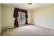 Carpeted bedroom with large window, radiator, and simple lighting fixture at 4401 Sombrero Cir, Littleton, CO 80123