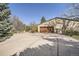 Long driveway leading to an attached garage, surrounded by greenery and mature trees at 4401 Sombrero Cir, Littleton, CO 80123