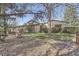 Charming single-story home with a well-maintained lawn, mature trees, and stone accents at 4401 Sombrero Cir, Littleton, CO 80123