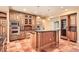Warm kitchen with an island, custom cabinets, stainless steel appliances and tile flooring at 4401 Sombrero Cir, Littleton, CO 80123