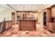 Warm kitchen with an island, custom cabinets, stainless steel appliances and tile flooring at 4401 Sombrero Cir, Littleton, CO 80123