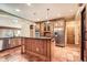 Well lit kitchen featuring stainless steel appliances, island and custom wood cabinets at 4401 Sombrero Cir, Littleton, CO 80123