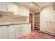Functional laundry room with ample cabinet space, open shelving, and terra cotta tile flooring at 4401 Sombrero Cir, Littleton, CO 80123