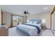 Spacious bedroom features a ceiling fan, large windows with curtains, and neutral carpet at 23 Carla Way, Broomfield, CO 80020
