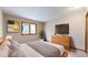 Bright bedroom featuring natural light, neutral walls and a wood dresser with decor and a TV at 23 Carla Way, Broomfield, CO 80020