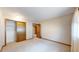 Neutral carpeted bedroom with bi-fold closet, neutral walls, and a view into another room at 23 Carla Way, Broomfield, CO 80020