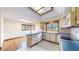 Bright kitchen features light wood cabinets, skylight, tile floor, and adjacent dining area at 23 Carla Way, Broomfield, CO 80020