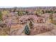A stunning aerial view of the home reveals its stone and wood exterior and beautiful surroundings with mature trees at 4700 Homestead St, Bow Mar, CO 80123