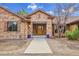 Welcoming front entrance with stone accents, a wooden door, and manicured landscaping create great curb appeal at 4700 Homestead St, Bow Mar, CO 80123
