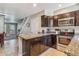 Stylish kitchen featuring dark cabinets, granite countertops, and stainless steel appliances at 12059 E Hoye Dr, Aurora, CO 80012