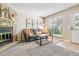 Comfortable living room showcasing a stone fireplace, plush sofa, and natural light from the window at 12059 E Hoye Dr, Aurora, CO 80012