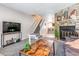 Spacious living room with a stone fireplace, staircase, and a view into the kitchen at 12059 E Hoye Dr, Aurora, CO 80012