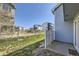 Backyard of townhouse featuring a concrete patio, small lawn, fence, and view of construction at 5873 Ceylon St # E, Denver, CO 80249