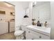 Bathroom featuring a vanity with a sink, a toilet and a washing machine area with front load washer and dryer at 5873 Ceylon St # E, Denver, CO 80249