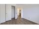 Bedroom featuring wood flooring, a sliding door closet, an open doorway, and light-colored walls at 5873 Ceylon St # E, Denver, CO 80249