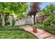 Beautiful backyard garden with lush greenery, stone walkway, and hanging flower baskets at 6112 Alkire Ct, Arvada, CO 80004