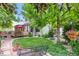 Expansive backyard lawn with mature trees, stone patio, and a charming wooden deck for entertaining at 6112 Alkire Ct, Arvada, CO 80004