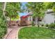 Picturesque backyard features a lush lawn, mature trees, and a cozy wooden deck with outdoor seating at 6112 Alkire Ct, Arvada, CO 80004