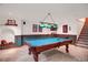Finished basement with pool table, custom lighting, and carpeted stairs at 6112 Alkire Ct, Arvada, CO 80004