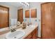Bathroom featuring a double sink vanity, neutral countertops, and classic oak cabinetry at 6112 Alkire Ct, Arvada, CO 80004