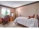 Bedroom featuring ample desk space, a bedside lamp, and comfortable carpeting at 6112 Alkire Ct, Arvada, CO 80004
