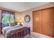 Bedroom with a decorative wall hanging, slider closet, and a view from the window at 6112 Alkire Ct, Arvada, CO 80004