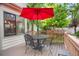 Wooden deck with seating and a bright red umbrella for shade at 6112 Alkire Ct, Arvada, CO 80004