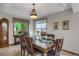 Formal dining room with chandelier, large windows, and elegant wood table and chairs at 6112 Alkire Ct, Arvada, CO 80004