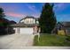 Beautiful two-story home featuring a well-manicured lawn, brick accents, and a three-car garage at 6112 Alkire Ct, Arvada, CO 80004