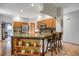 Open kitchen featuring a granite island with seating, stainless steel appliances and wood cabinets at 6112 Alkire Ct, Arvada, CO 80004
