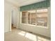 Serene bedroom with large grid windows and a glimpse into the landscaped yard through sheer curtains at 2238 Calais Dr # B, Longmont, CO 80504
