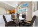 Bright dining room featuring a chandelier, a round glass table, and a large window with flower patterned valance at 2238 Calais Dr # B, Longmont, CO 80504