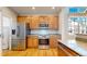 Open kitchen with stainless steel appliances, wooden cabinets, and hardwood floors at 2238 Calais Dr # B, Longmont, CO 80504