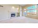 Cozy living room featuring a fireplace, high ceilings, neutral carpet, and bright natural light from a window and glass door at 2238 Calais Dr # B, Longmont, CO 80504