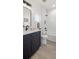 Modern bathroom with navy blue vanity, white subway tile, and stylish fixtures at 4511 Tabor St, Wheat Ridge, CO 80033