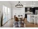 Bright dining area with modern chandelier, leading to a modern kitchen and natural light at 4511 Tabor St, Wheat Ridge, CO 80033