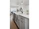 Close up of a kitchen island featuring a farmhouse sink, modern faucet, and brass hardware at 4511 Tabor St, Wheat Ridge, CO 80033