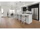 Modern kitchen features a large island with seating, stainless steel appliances, and hardwood floors at 4511 Tabor St, Wheat Ridge, CO 80033