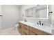 Bathroom with double vanity, quartz countertop, wood cabinets, and illuminated mirror at 1306 Yates St, Denver, CO 80204