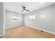 Bright bedroom featuring hardwood floors, a modern ceiling fan, and three windows for ample sunlight at 1306 Yates St, Denver, CO 80204