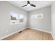 Bright bedroom featuring hardwood floors, a modern ceiling fan, and multiple windows at 1306 Yates St, Denver, CO 80204