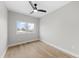 Minimalist bedroom featuring hardwood floors, a modern ceiling fan, and a large window at 1306 Yates St, Denver, CO 80204